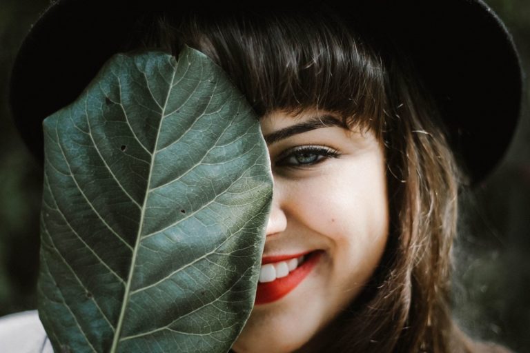Woman's face partially covered by leaf