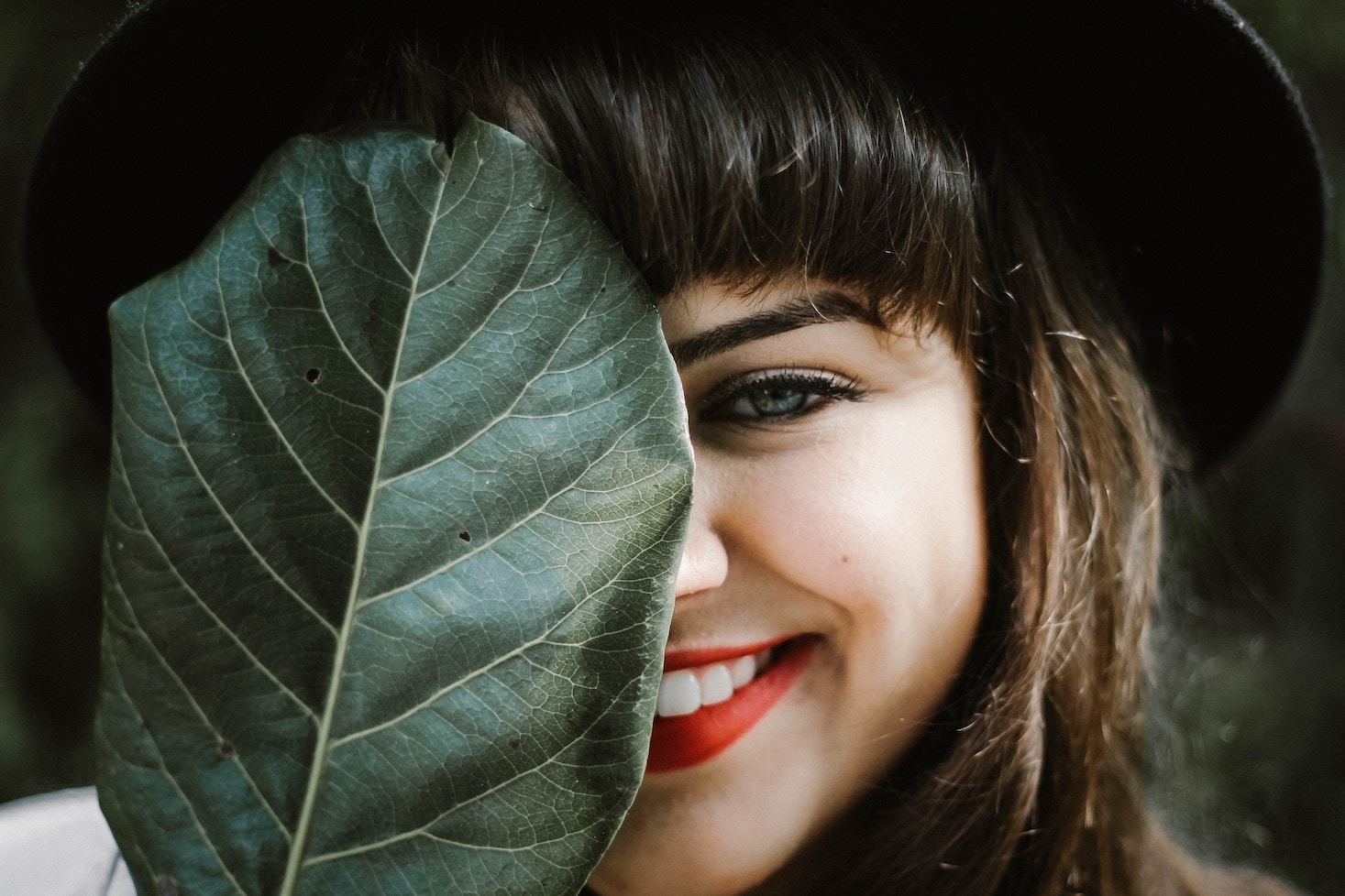 Woman's face partially covered by leaf