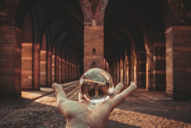 Hand holding crystal ball in palace