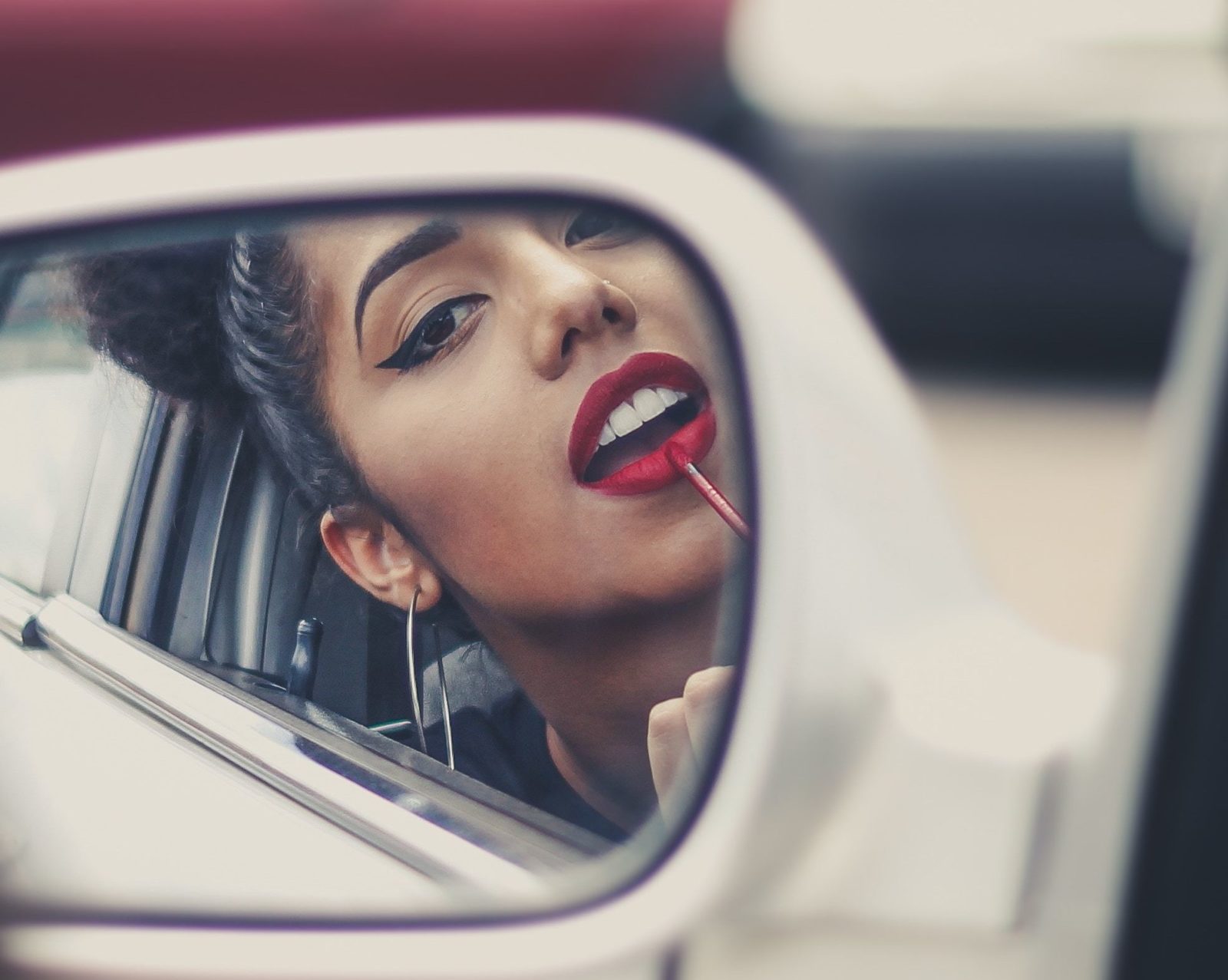 Woman applying makeup in car