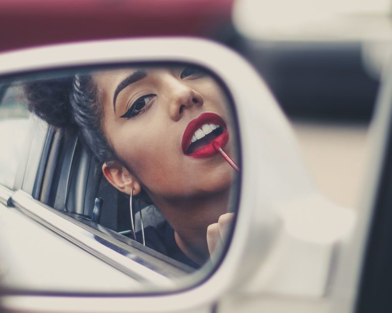 Woman applying makeup in car