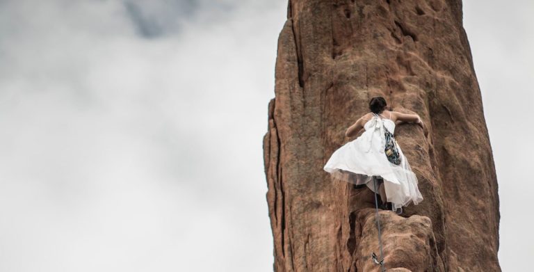 Woman climbing cliff edge