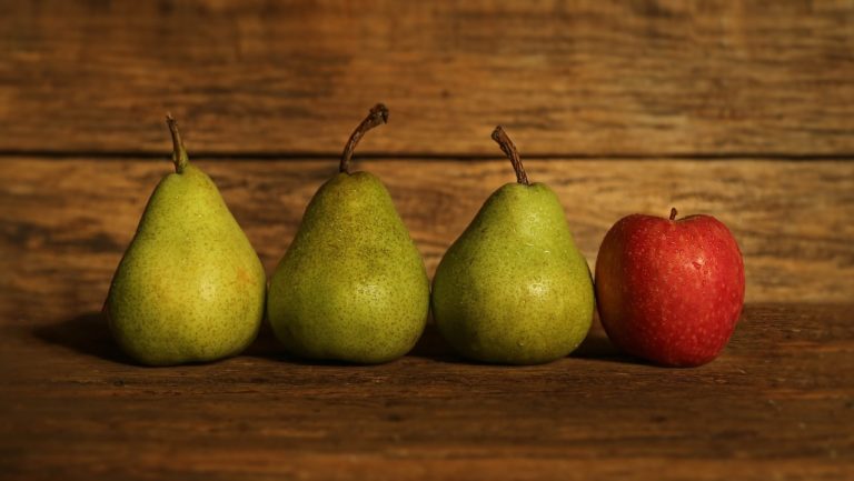 Red apple among green pears