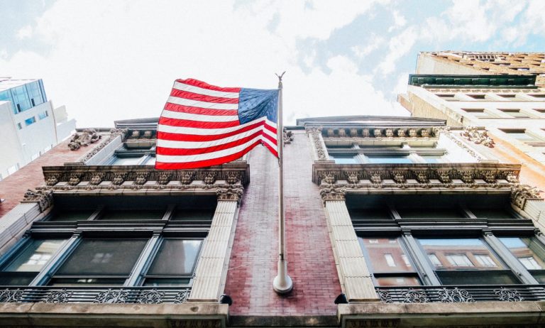 worm's-eye view of buildings and American flag