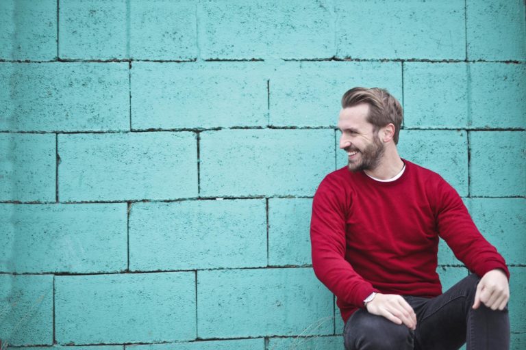 Well-dressed man leaning against a wall