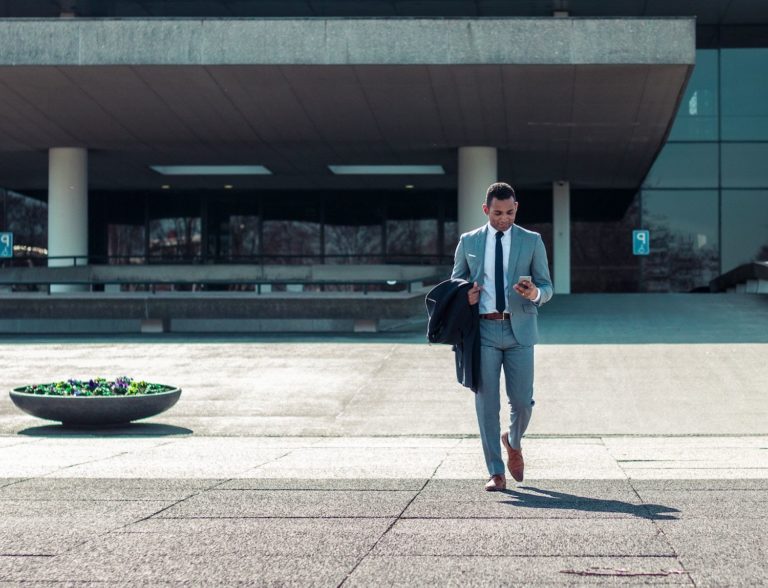 Business man walking out of building