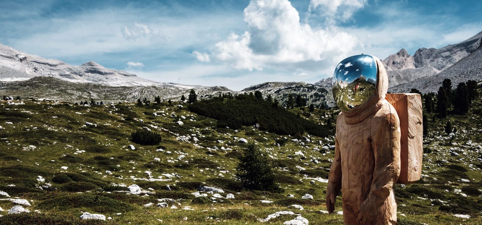 A man hikes through the Swiss Alps in a hazmat suit