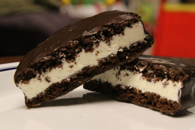 A MoonPie marshmallow snack cake cut into halves on a plate