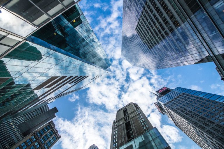 A low-angle shot of skyscrapers against a blue sky