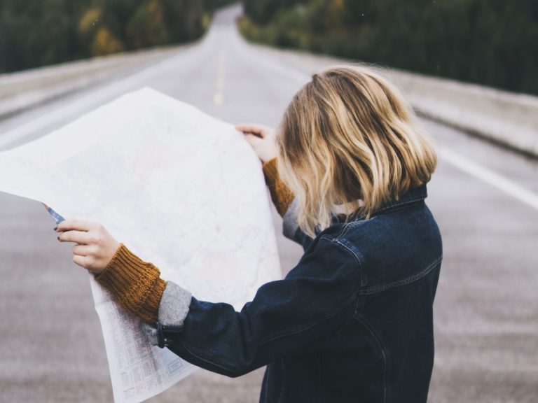 Girl on road holding map