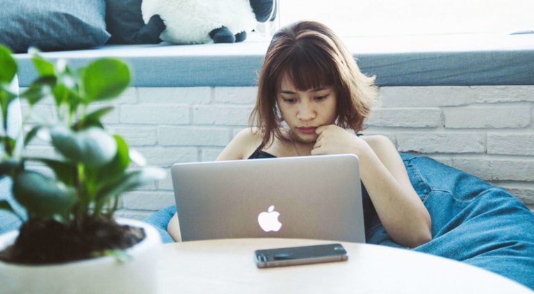 Woman reading with laptop