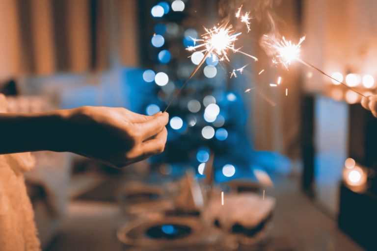 two hands holding sparklers