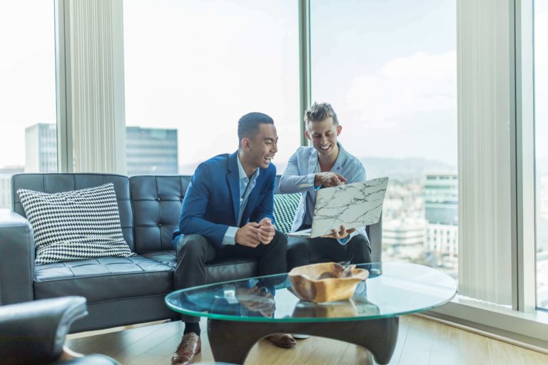 Two men share feedback while looking at a project.