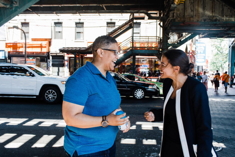 Kerri Evelyn Harris, left, and Alexandria Ocasio-Cortez, right, talk on a street.