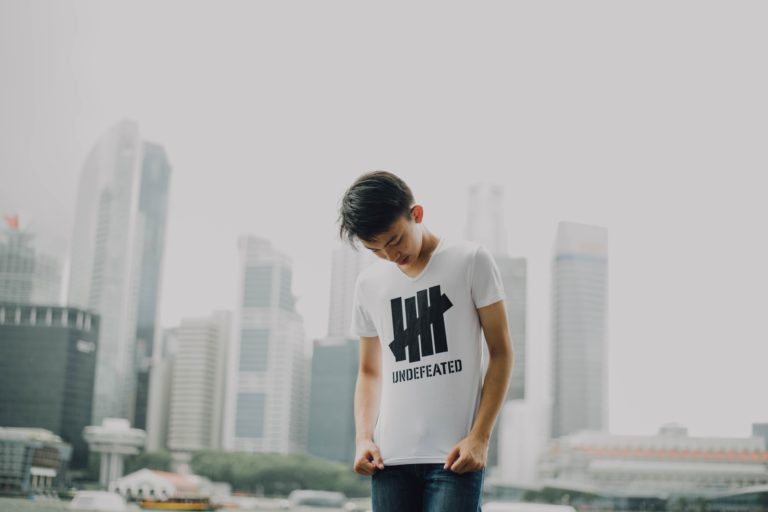 A boy looks down at his sports brand T-shirt.