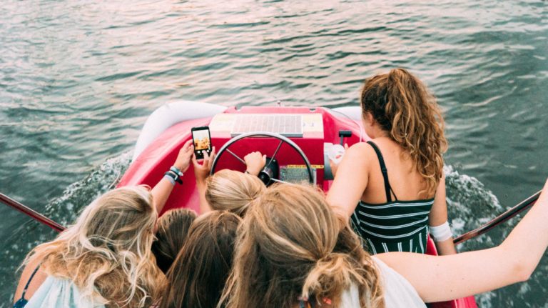 Girls taking selfies on a boat