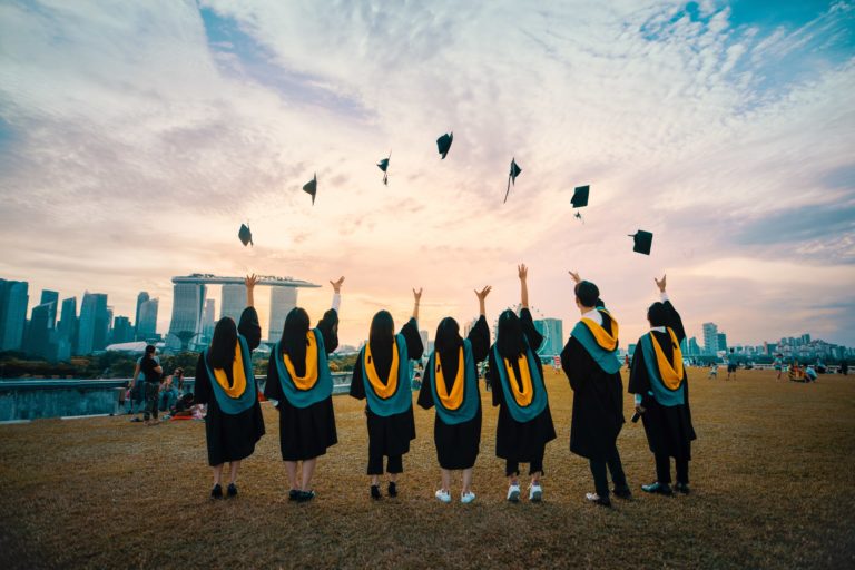 College students throwing their graduation caps in the air.