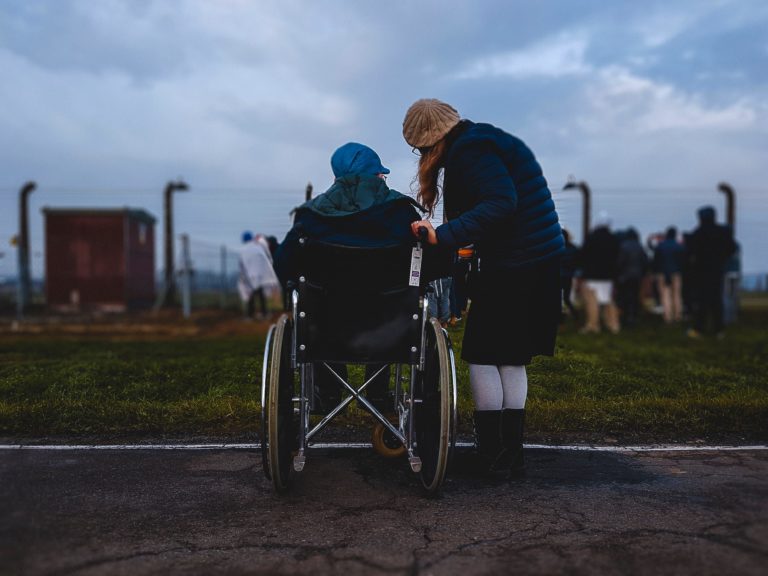A competitive wheelchair racer treks down a street.