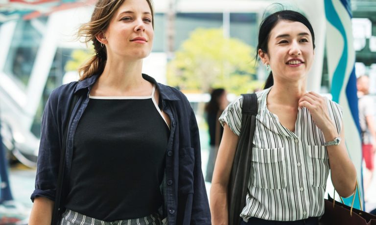 Two women walk through a shopping mall.