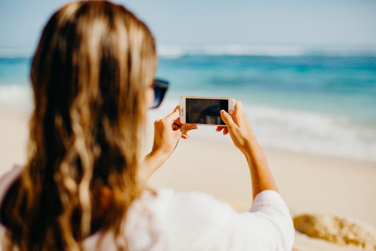 Girl taking a photo on the beach.