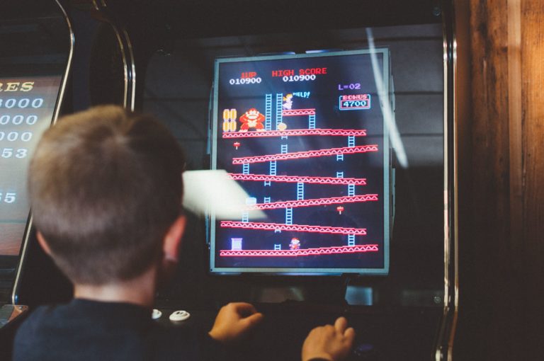 A boy plays a video game at an arcade