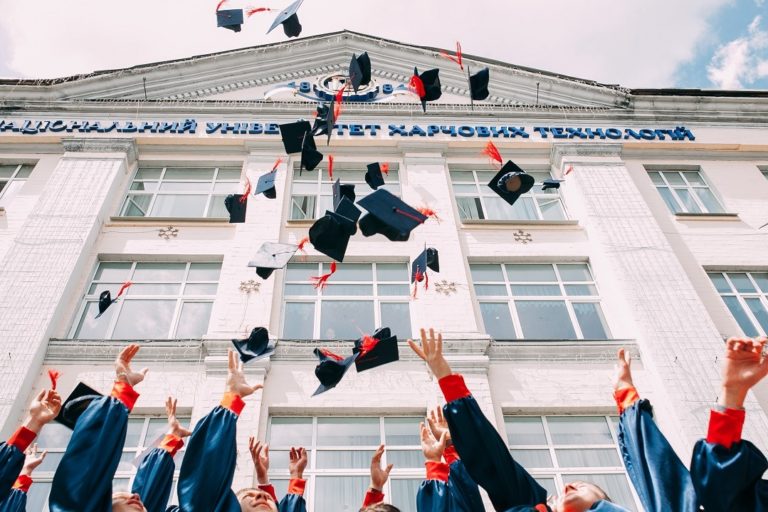 Image of college students throwing graduation caps in the air.