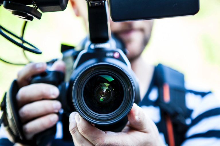 A man shoots a video for social media using a digital camera.