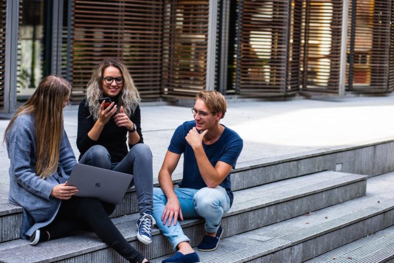 A trio of B2B tech writers gather on some steps.
