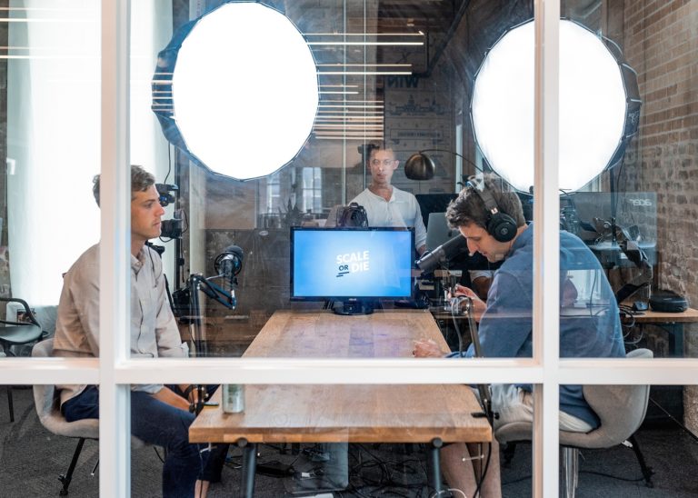 A group of businessmen learns how to host a webinar in a conference room.