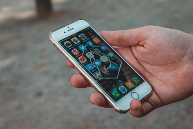 A cellphone with social media apps displayed on the screen.