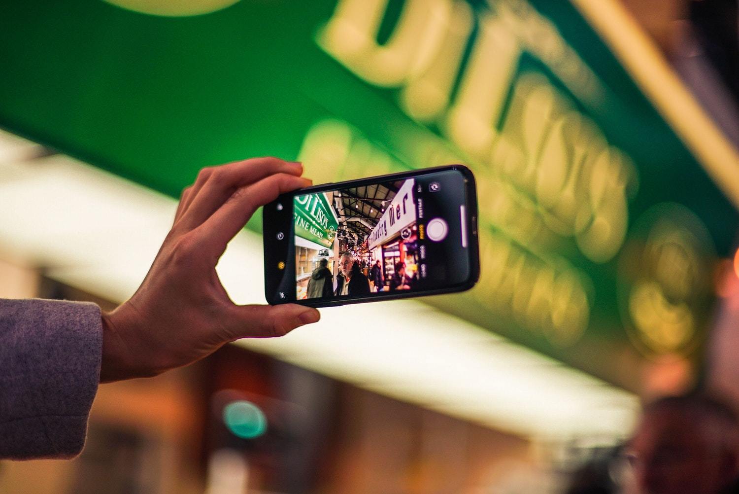 A man uses a smartphone to create a campaign for his video content marketing strategy.