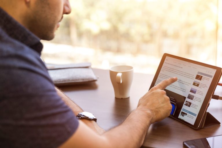 A man uses LinkedIn on a tablet.