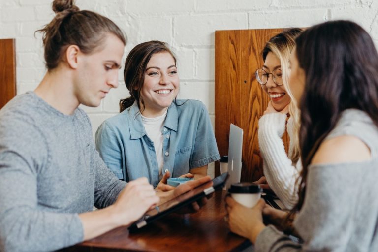 A group of young adults discusses an employee advocacy program.