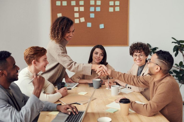 Employees collaborate during a boardroom meeting regarding marketing and sales alignment.