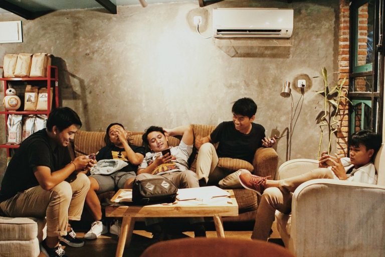 A group of young people browse social media feeds on their phones