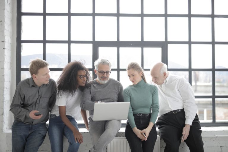 A group of marketers gather around a laptop to discuss the latest Google algorithm change