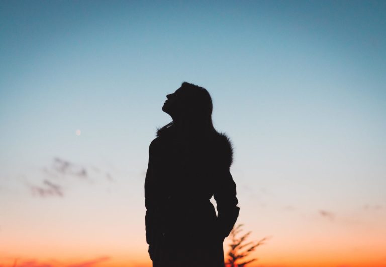 A woman who has created a marketing resilience looks up hopefully at the sky.