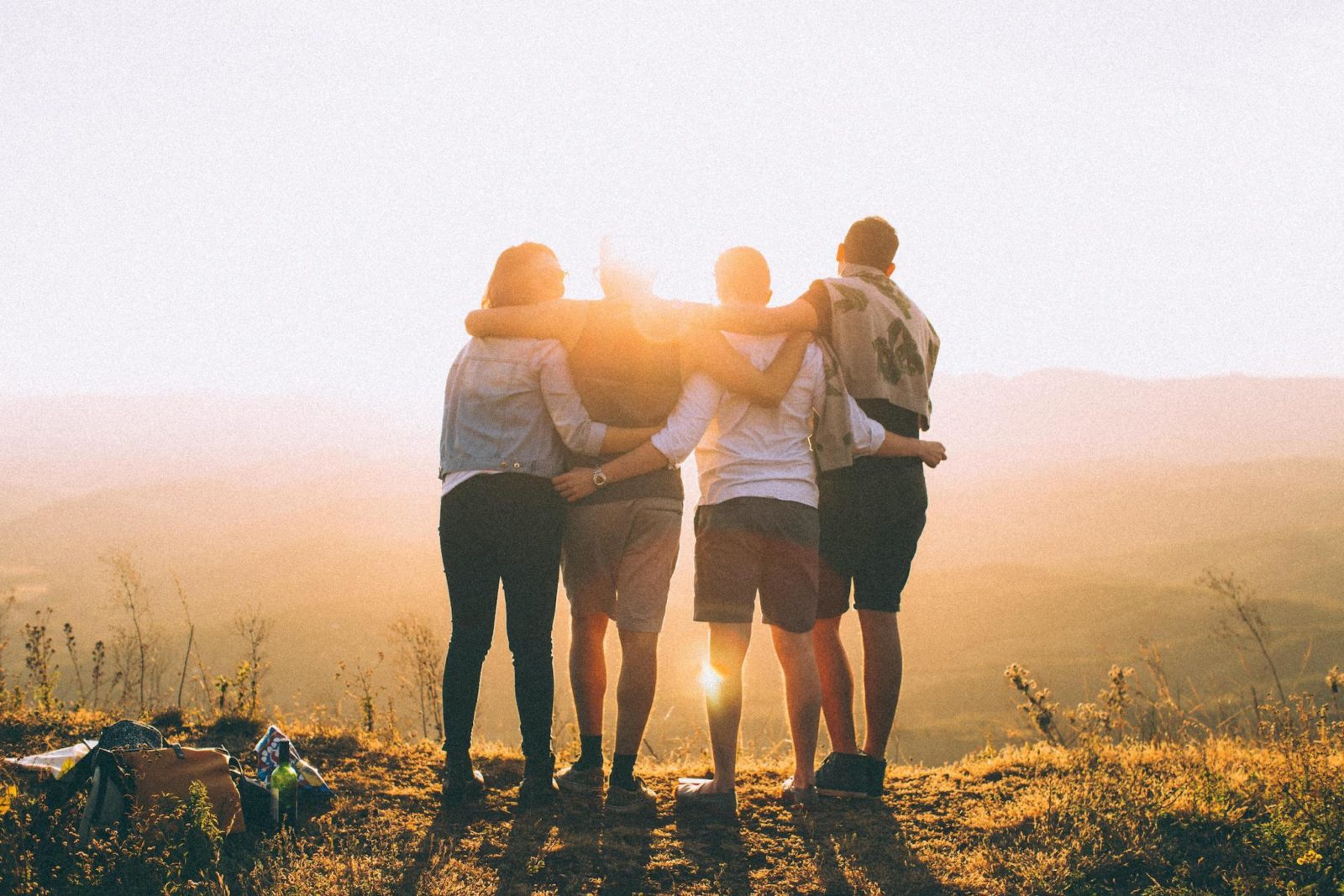 People embracing while looking at a horizon.