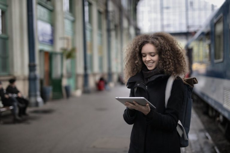 A woman in the retention stage of the audience journey looks at content on a tablet.