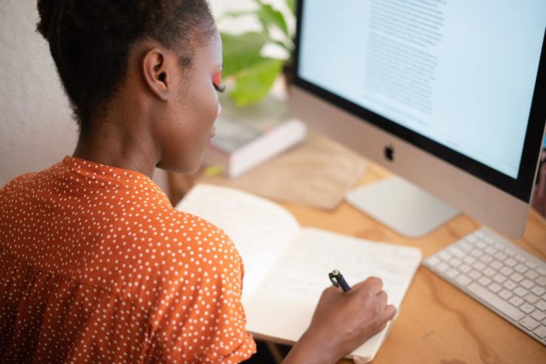 Young marketing professional making notes on her content audit strategy at her desk.
