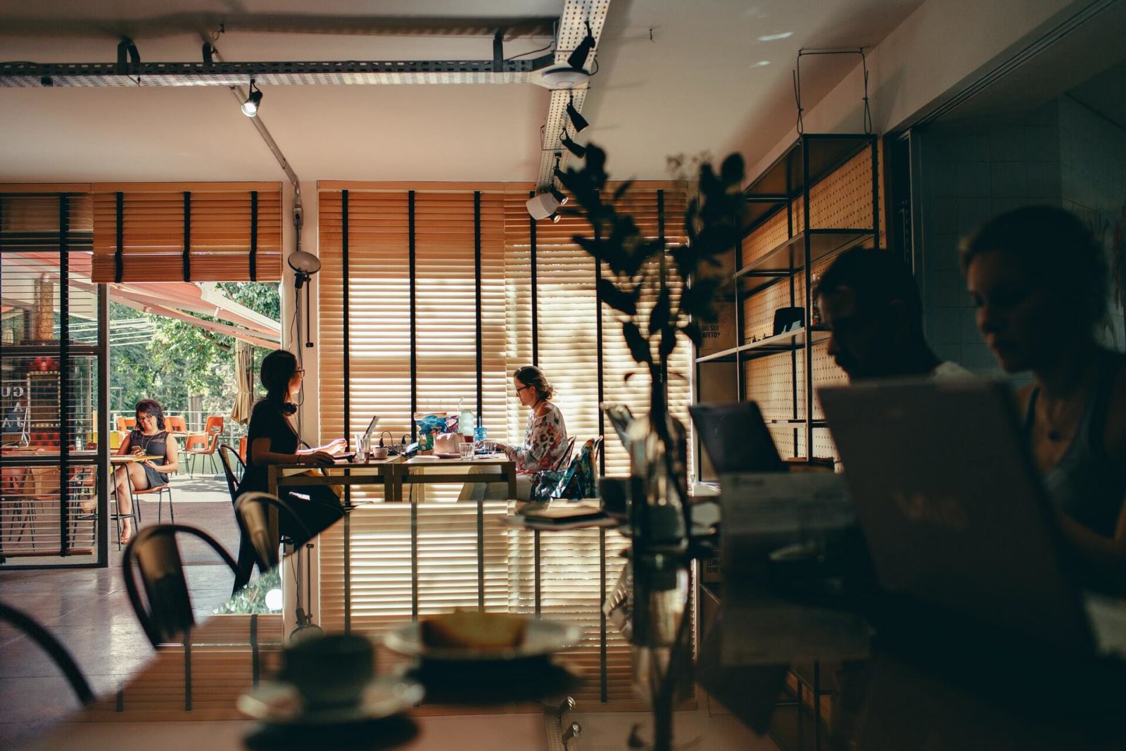 People work inside and outside at a coffee shop.