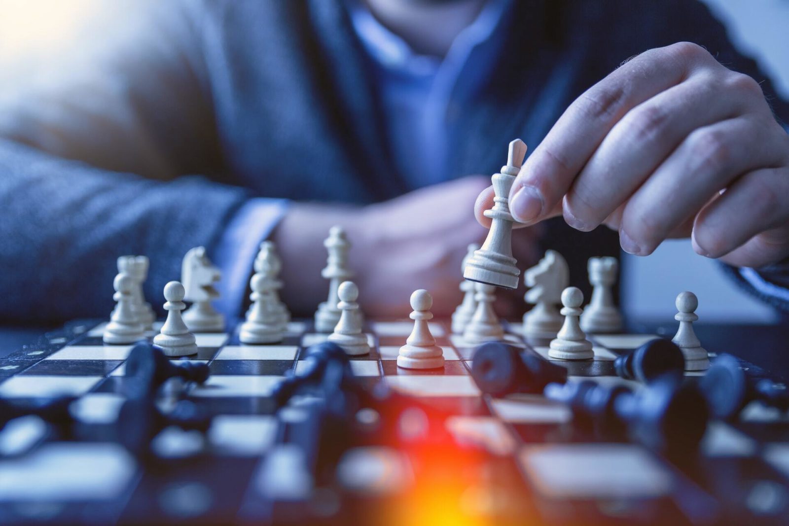 Chess master plays a game over a backlit board.